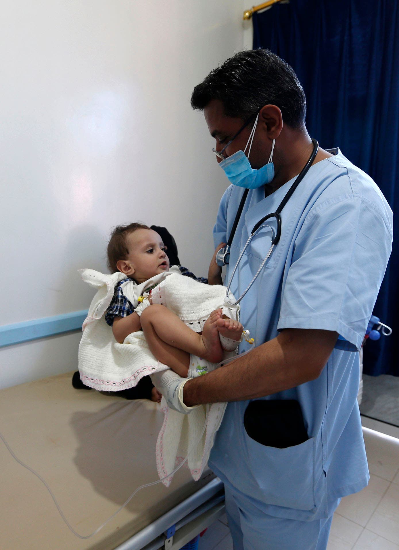 A Yemeni mother sits near her child suspected of being infected with cholera receiving treatment at a hospital in Sanaa on May 25, 2017. (AFP)