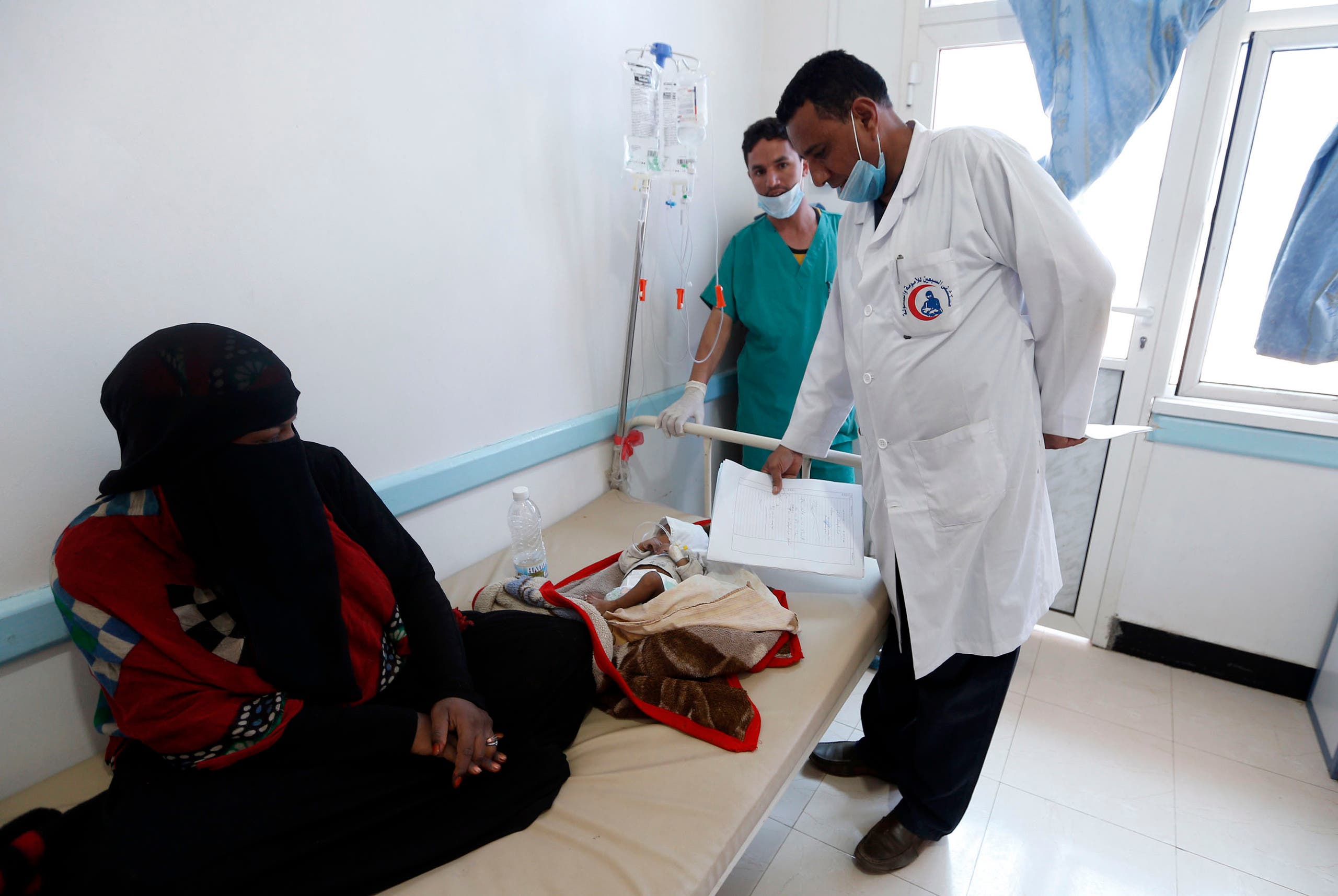 A Yemeni mother sits near her child suspected of being infected with cholera receiving treatment at a hospital in Sanaa on May 25, 2017. (AFP)