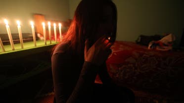 A Syrian sex trafficking victim smokes a cigarette at her safehouse at an undisclosed location in Lebanon on April 13, 2016, after she fled a brothel in Lebanon where she was being held captive. AFP