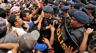 Supporters of Bali bombers Amrozi Nurhasyim and Ali Ghufron scuffle with riot police during their funeral in Lamongan, East Java, Indonesia, Sunday, Nov. 9, 2008. 