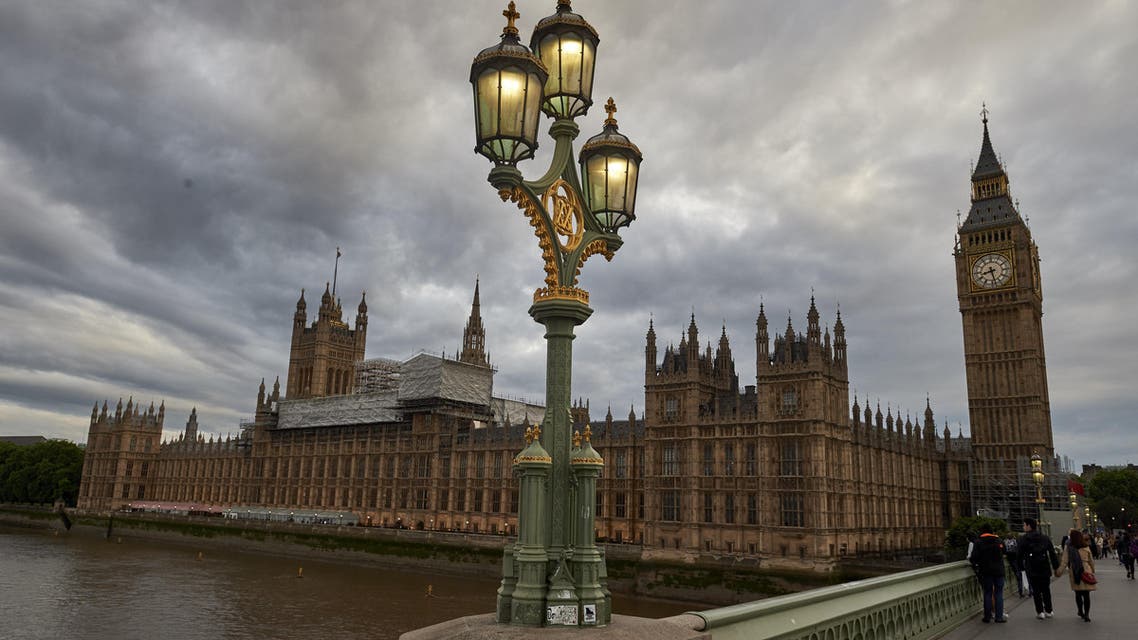 a couple stroll along Westminster Bridge towards the Elizabeth Tower, commonly referred to as Big Ben, and the Houses of Parliament are seen from the south bank of the river Thames in central London on June 8, 2017.