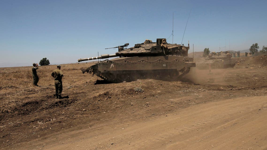 Israeli soldiers direct a Merkava tank stationed in the Israeli annexed Golan Heights near the Quneitra crossing with Syria on July 26, 2016.