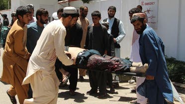 Afghan men carry a victim of a powerful car bomb in Lashkar Gah, the capital of Helmand province, on June 22, 2017. Twenty people were killed June 22 when a powerful car bomb struck a bank in Afghanistan's Lashkar Gah city as government employees were queueing to withdraw salaries, the latest bloody attack during the holy month of Ramadan. (AFP)