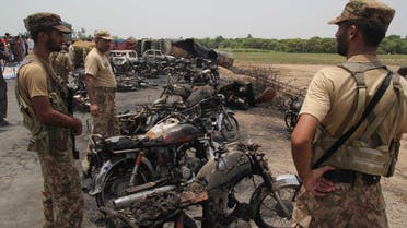 Pakistani soldiers stand guard beside burnt out vehicles at the scene where an oil tanker caught fire near the town of Ahmedpur East, some 670 kms from Islamabad on June 25, 2017. (AFP)