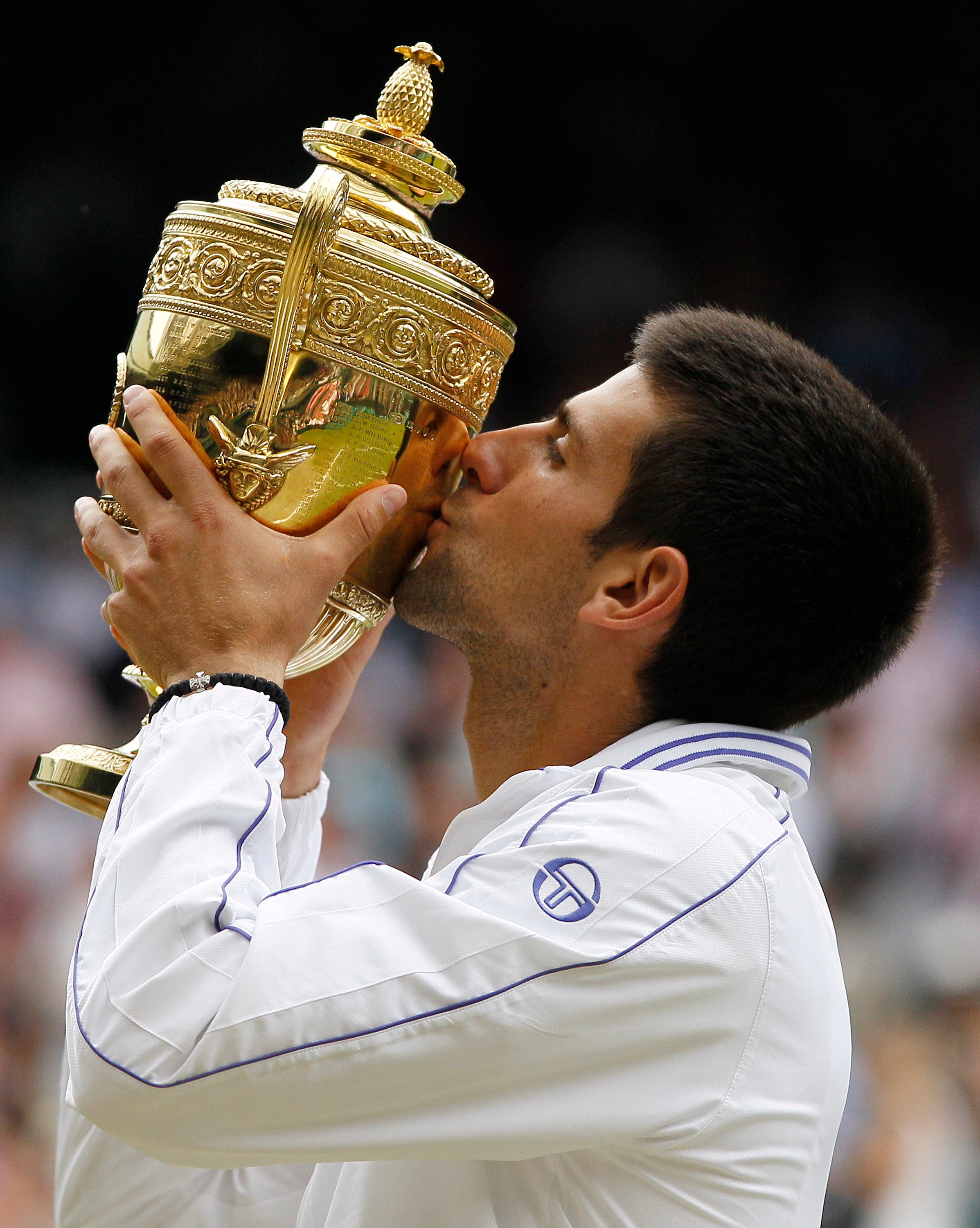 This July 3, 2011 file photo shows Serbia's Novak Djokovic kissing the trophy after defeating Spain's Rafael Nadal in the men's singles final at the All England Lawn Tennis Championships, at Wimbledon. AP