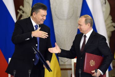 Russia’s President Vladimir Putin (R) and Ukrainian President Viktor Yanukovych shake hands after signing documents during their meeting in the Kremlin in Moscow, on December 17, 2013. (AFP)