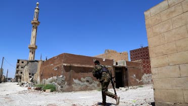 A member of the Syrian Democratic Forces (SDF) crosses a street on June 27, 2017 in the suburb of Dariya on the western city limits of Raqqa after the area was seized by SDF from the ISIS. (AFP)