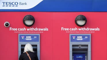 A customer uses an RBS branded automated teller machine (ATM), at a Tesco Bank cash point, in Liverpool, north west England, on November 7, 2016. (AFP)