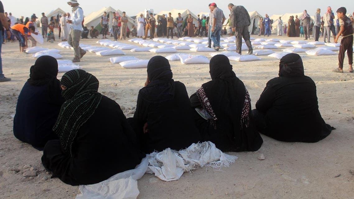Iraqi women displaced from Ramadi, sit and wait to receive aid from the International Committee of the Red Cross (ICRC) at a makeshift camp where they are taking shelter in Habbaniyah, just east of the capital of Iraq's Anbar province. (AFP)