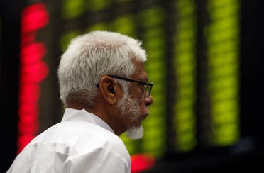 A man monitors an electronic board displaying share market prices during a trading session in the halls of Pakistan Stock Exchange (PSX) in Karachi, Pakistan, on June 12, 2017. (Reuters)