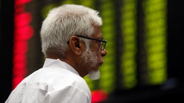 A man monitors an electronic board displaying share market prices during a trading session in the halls of Pakistan Stock Exchange (PSX) in Karachi, Pakistan, on June 12, 2017. (Reuters)