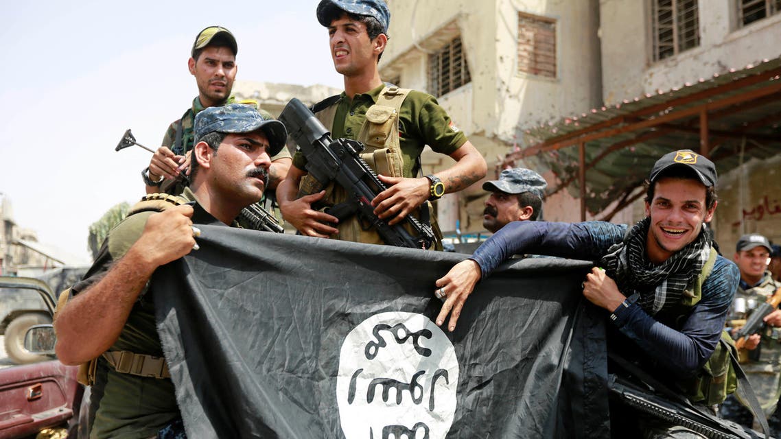 Iraqi Federal Police members hold an Islamic State flag, which they pulled down during fighting between Iraqi forces and ISIS militants, in the Old City of Mosul, Iraq July 4, 2017. (AP)