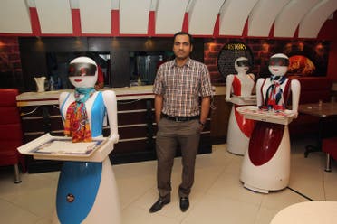  Pakistani engineer Osama Jafari (C) poses with robot waitresses Annie (L), Rabia (R) and Jennie (background) at his pizza restaurant in Multan. (AFP)