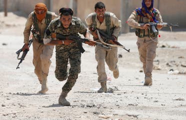 Kurdish fighters from the People’s Protection Units (YPG) run across a street in Raqqa, Syria July 3, 2017. (Reuters)