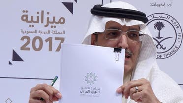 Saudi Finance Minister Mohammed Al-Jadaan shows documents during a press conference to unveil the country's national budget for 2017. (AFP)