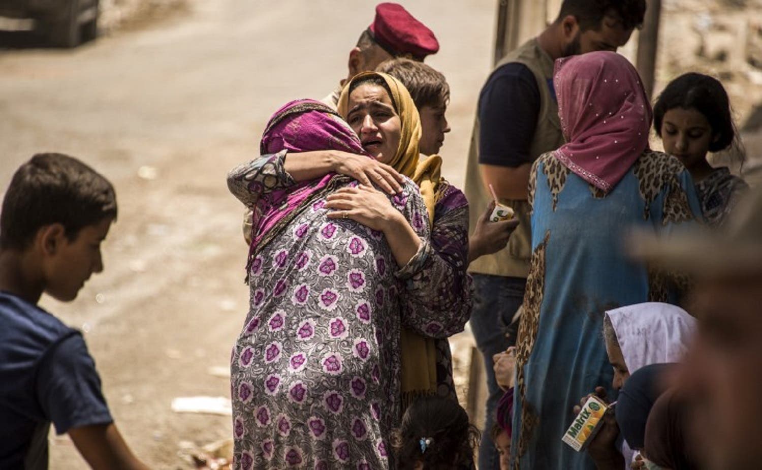 An Iraqi woman, who fled the fighting between government forces and ISIS militants in the Old City of Mosul, reacts while embracing another in the city’s western industrial district as they wait to be relocated, on July 8, 2017. (AFP)