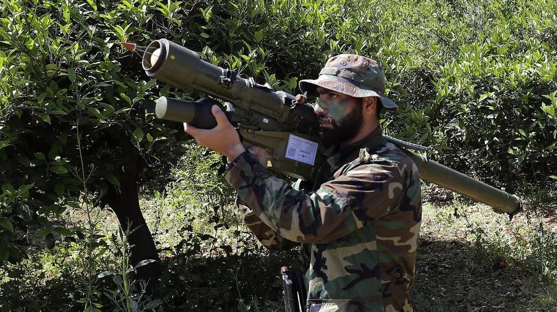A Hezbollah fighter is seen standing at attention in an orange field near the town of Naqura on the Lebanese-Israeli border on April 20, 2017. (AFP)