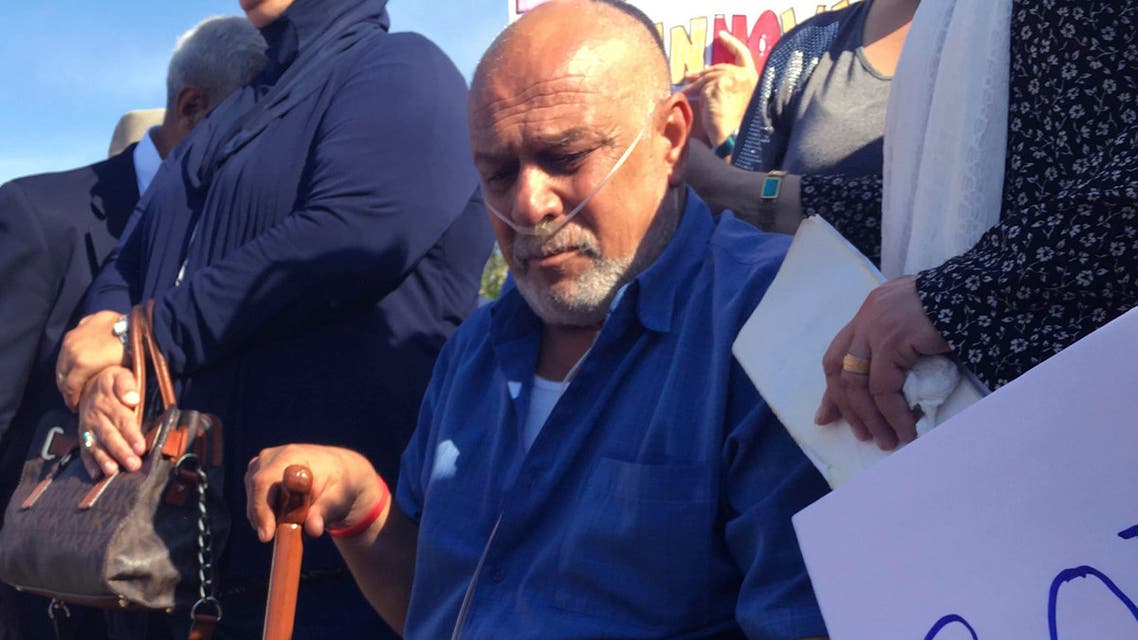 In this June 26, 2017 file photo Kadhim Al-bumohammed, center, a 64-year-old Iraqi refugee in the U.S., listens to speakers at an Albuquerque rally in his honor. AP