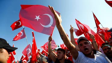 People wave Turkey's national flags as they arrive to attend a ceremony marking the first anniversary of the attempted coup at the Bosphorus Bridge in Istanbul, Turkey July 15, 2017. REUTERS/Murad Sezer
