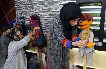 Afghan puppeteers setting props for Sesame Street's new Afghan character, a 4-year-old Afghan puppet boy called Zeerak, right, and Zari, before a recoding a segment for Afghan version of Sesame Street called Baghch-e-Simsim for the sixth season of the program aired on TOLO a Local Television station in Kabul, Afghanistan. (Rahmat Gul/AP)