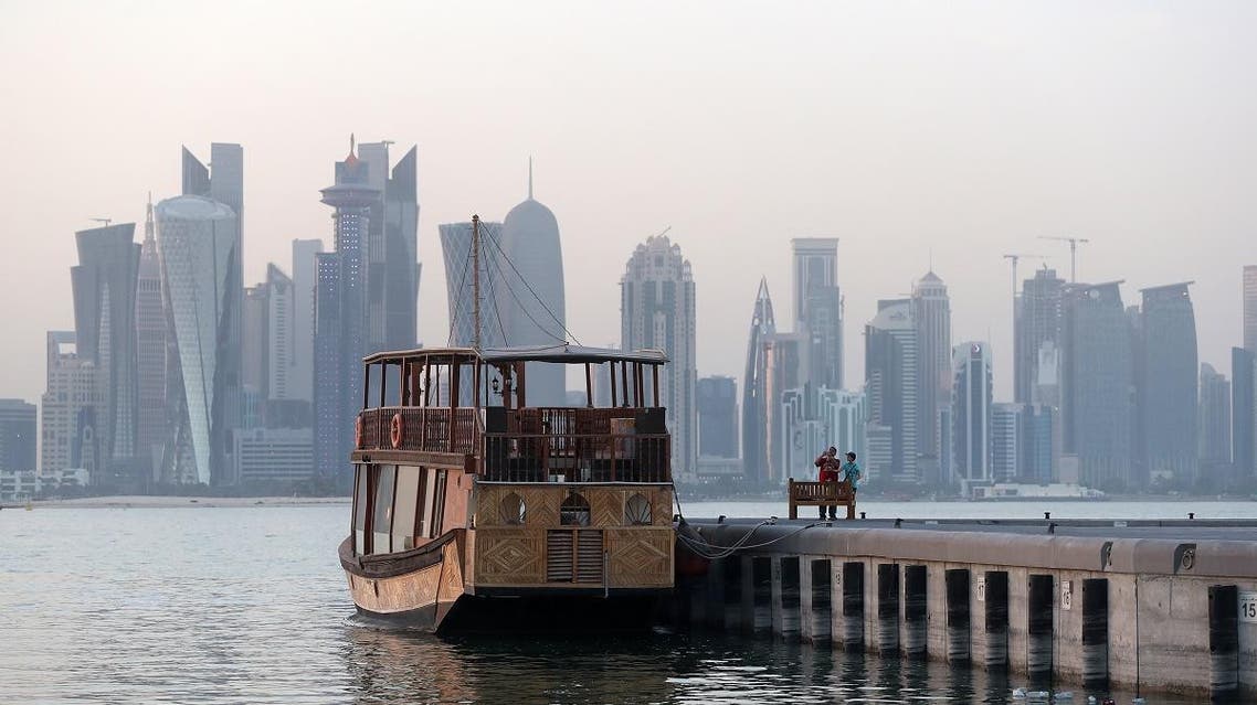 Boys take picture of a boat on the corniche in the Qatari capital Doha on July 2, 2017. (AFP)