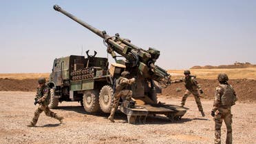 French soldiers from the Wagram Task Force stand next to a unit of CAESAR, a French self-propelled 155 mm howitzer, north of Mosul on July 13, 2017, as the French army provides military support for Iraq forces fighting the Islamic State (IS) group. The Iraqi prime minister Haider al-Abadi on July 10 declared Mosul finally retaken from the Islamic State group, which seized the city and swathes of other territory in 2014. (AFP)
