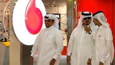 Men walk past a Vodafone-Qatar Telecommunication office in Doha on October 22, 2009. (Reuters)