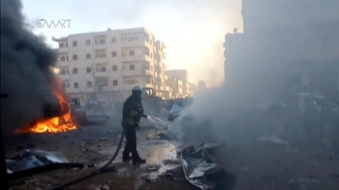 A still image taken from a video posted to a social media website on June 24, 2017, shows a civil defense member trying to put out a fire at the site of a car bomb, said to be in the town of al-Dana, Idlib. (Reuters)