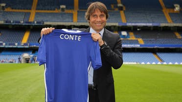 Antonio Conte holds a Chelsea football shirt as he poses for photographs on the pitch at the club’s Stamford Bridge stadium in London on July 14, 2016. (AFP)