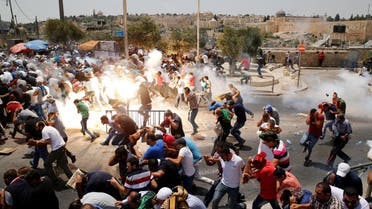 Palestinians react following tear gas that was shot by Israeli forces after Friday prayer on a street outside Jerusalem's Old city July 21, 2017. (Reuters)