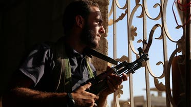 A Free Syrian Army fighter looks out through a window in rebel-held Al-Yadudah village, in Deraa Governorate, Syria, on July 19, 2017. (Reuters)