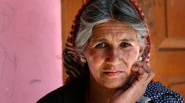 In this Dec. 15, 2013 photograph, Bijaya Devi, 64, the oldest widow of the village stands at her house at the Deoli-Benigram village in Rudraprayag district, in the northern state of Uttarakhand, India.