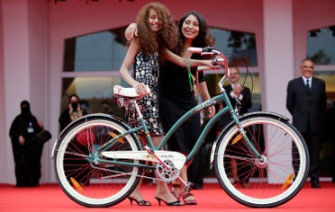 Saudi Arabian director Haifaa al-Mansour (R) and actress Waad Mohammed pose with a bicycle on the red carpet during the premiere screening of Wadjda during the 69th Venice Film Festival in Venice August 31, 2012. (Reuters)