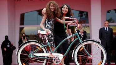 Saudi Arabian director Haifaa al-Mansour (R) and actress Waad Mohammed pose with a bicycle on the red carpet during the premiere screening of "Wadjda" during the 69th Venice Film Festival in Venice August 31, 2012. (Reuters)