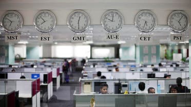 Workers are pictured beneath clocks displaying time zones in various parts of the world at an outsourcing center in Bangalore February 29, 2012. (Reuters)