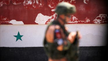 A Russian soldier stands guard near a Syrian national flag, Syria May 21, 2017. (Reuters)