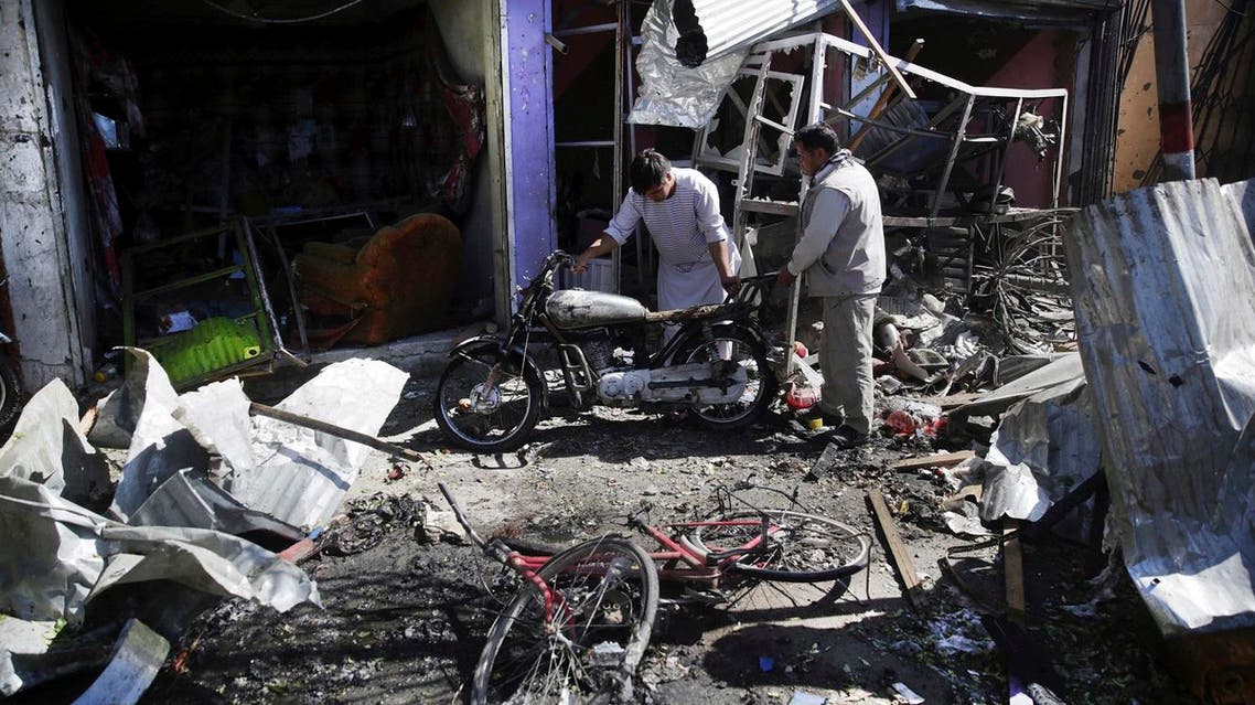 Men look at the remains of their properties at the site of a suicide attack in Kabul, Afghanistan. (AP)