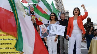 People chant slogans and hold pre-revolutionary Iranian flags in Paris, on August 17, 2013, as they take part in a rally marking the 25th anniversary of the 1988 massacre of Iranian political prisoners. (AFP)