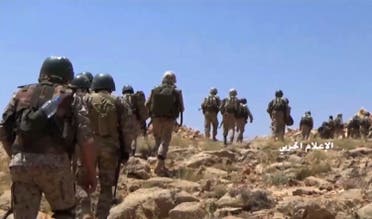 This frame grab from video released on July 22, 2017 shows Hezbollah fighters advancing up a hill during clashes with al-Qaeda-linked militants in an area on the Lebanon-Syria border. (AP)