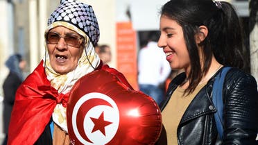 Tunisian women hold a ballon with their national flag during a rally on January 14, 2016 in the Habib Bourguiba Avenue in the capital Tunis to mark the fifth anniversary of the 2011 revolution. AFP