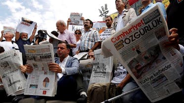 Press freedom activists read Cumhuriyet during a protest in solidarity with the jailed members of the newspaper outside a courthouse in Istanbul. (Reuters)
