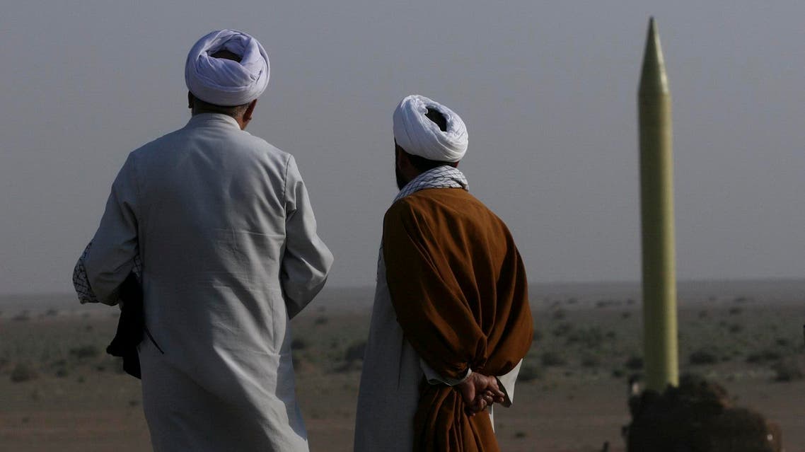 Two Iranian clerics stand near a surface-to-surface missile, which is ready to launch during a war game near the city of Qom on June 28, 2011. (Reuters)