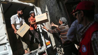 A picture taken on July 30, 2017 shows aid packages from the United Nations and the Syrian Arab Red Crescent (SARC) being delivered to locals in the rebel-held town of Nashabiyah in eastern Ghouta for the first time in five years. AMER ALMOHIBANY / AFP