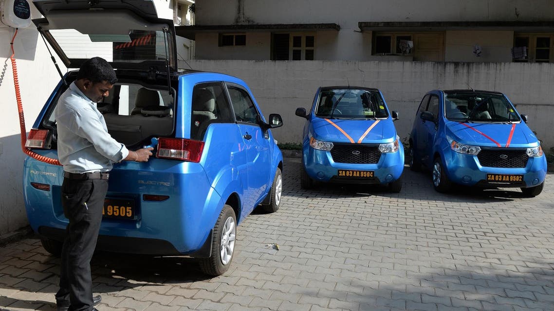 An employee of Indian company Carzonrent plugs in a Mahindra Reva electric car to charge in Bangalore on October 1, 2013. (AFP)