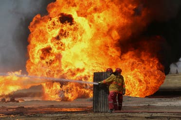 Oil workers and firemen try to extinguish flames at the Khabbaz oil field some 20 km away from Kirkuk on June 1, 2016 following an attack by ISIS. (AFP)