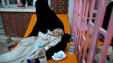A woman holds her son who is suspected of being infected with cholera at a cholera treatment center in Sanaa. (Reuters)