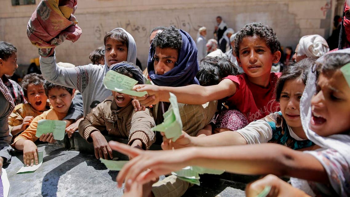 Yemenis present documents in order to receive food rations provided by a local charity, in Sanaa, Yemen. (AP)