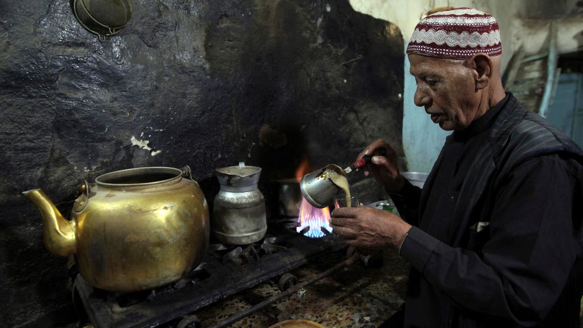A vendor pours coffee into a cup for customers inside his cafe in the old city of Al-Masnaah in Al-Mahaweet, around 110 km (68 miles) north west of capital Sanaa June 27, 2013. REUTERS/Mohamed al-Sayaghi