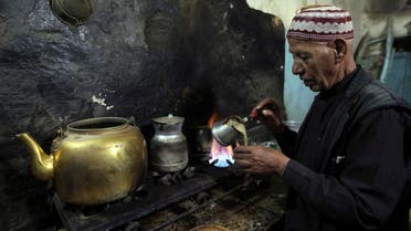A vendor pours coffee into a cup for customers inside his cafe in the old city of Al-Masnaah in Al-Mahaweet, around 110 km (68 miles) north west of capital Sanaa June 27, 2013. REUTERS/Mohamed al-Sayaghi 