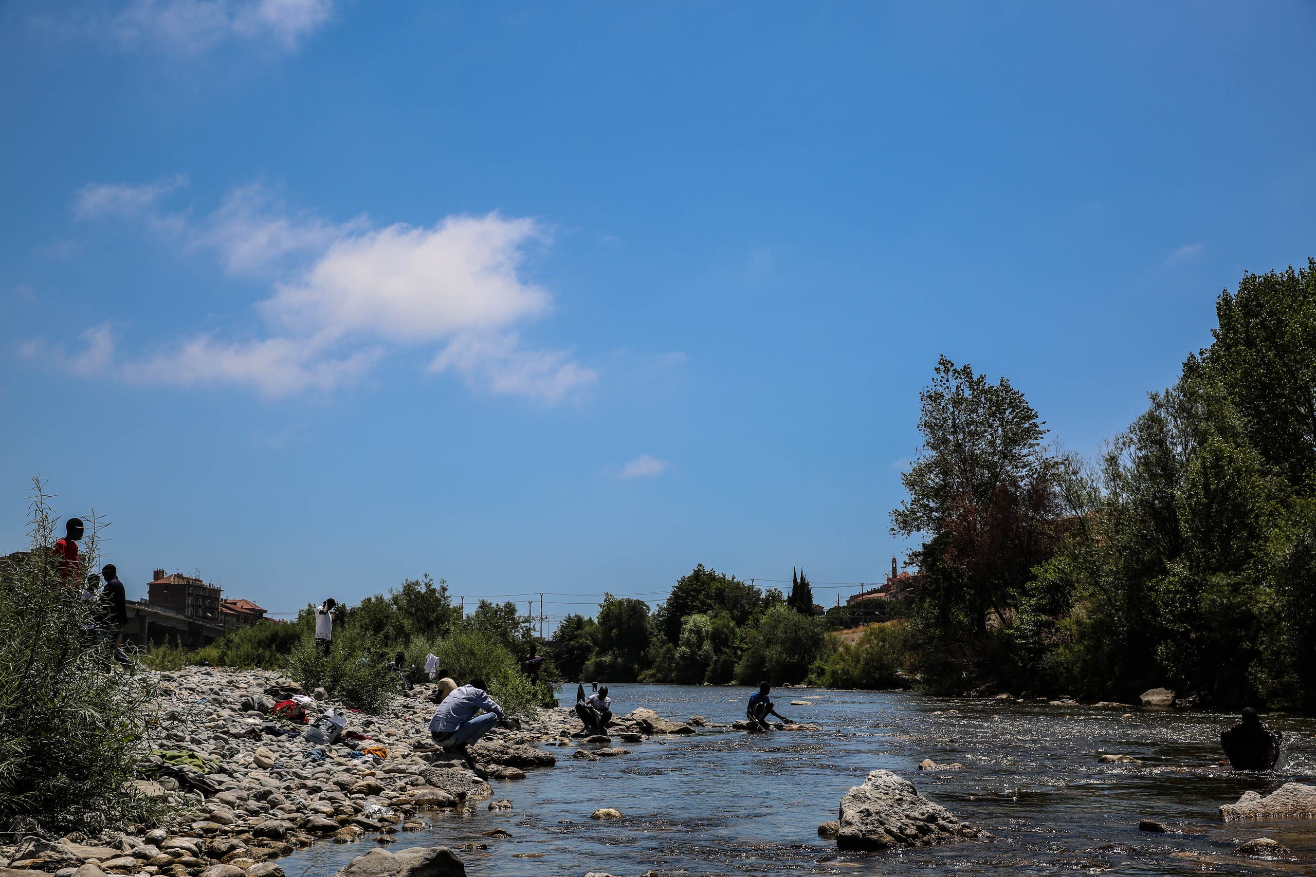 With lack of services, people who are living rough under the bridge are using Roya river to shower and wash.